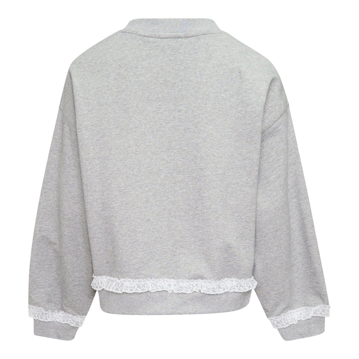 Ganni Isoli Sweater in heather grey marl with white lace frill trim at the hem and cuffs, and an embroidered heart-shaped Ganni logo patch on the chest