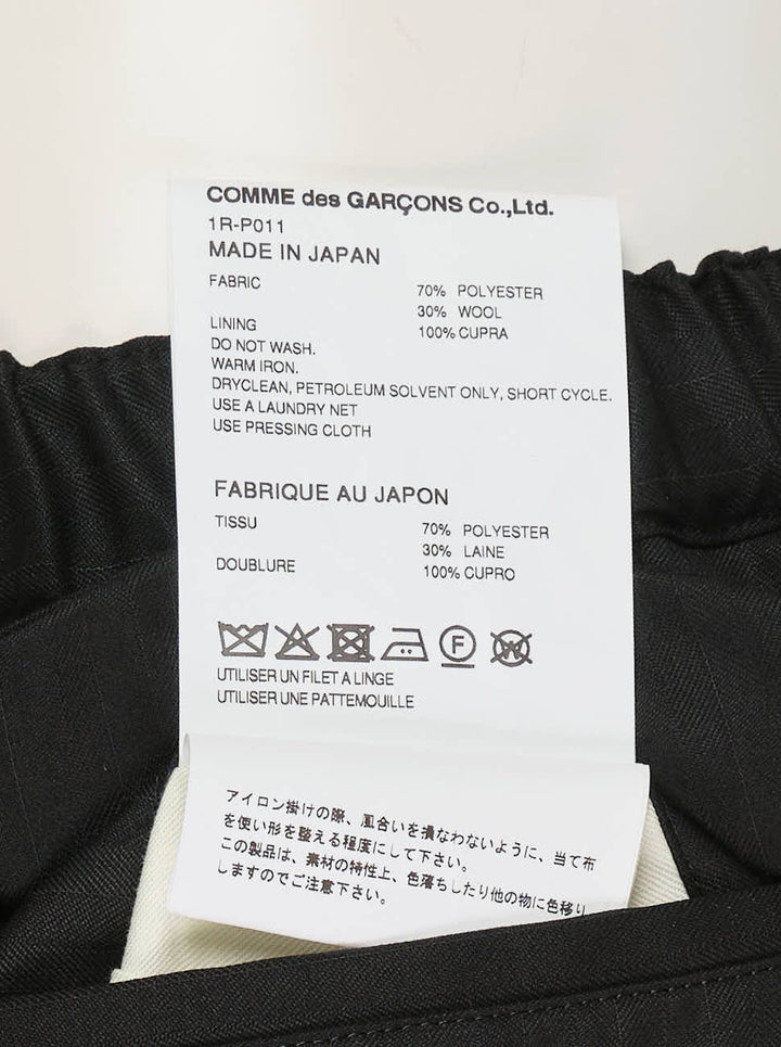 Comme des Garçons Black pleated balloon trousers in black polyester and wool herringbone with an elasticated waist, shown from the front - view 3