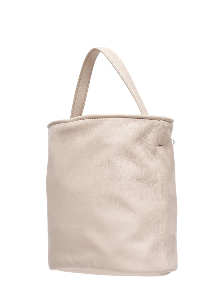 Marge Sherwood Wired Bucket Bag in pebbled cream leather with a single top handle, three silver chain drops, and a sculptural metal charm pendant at centre - view 2