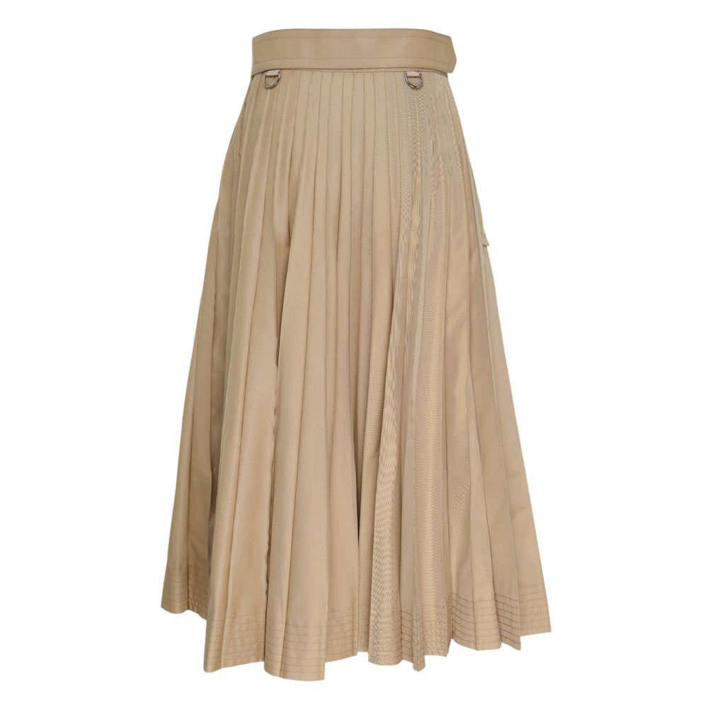 sacai Cotton Gabardine Pleated Skirt in khaki, featuring knife pleats, a belted waistband with gunmetal buckle, D-ring hardware, and a button-fastened pocket flap