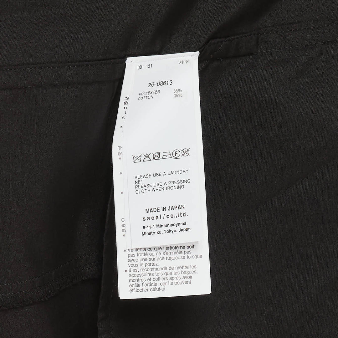 sacai black cotton poplin short-sleeve shirt dress with oversized bow waist detail and voluminous pleated skirt, front view on white background