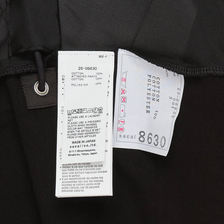 sacai Thinking Becoming Graphic Tee in black with arched collegiate print and sheer drawstring side panels