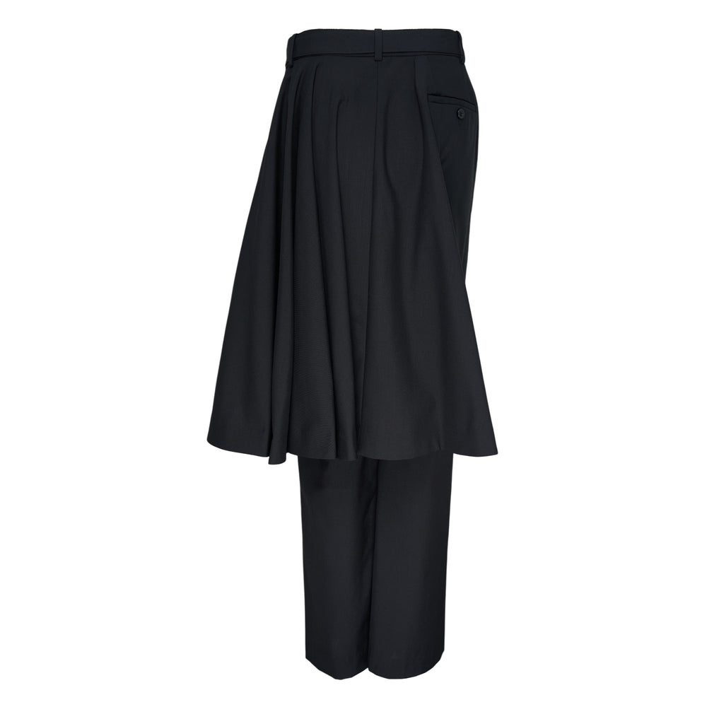 sacai black suiting pants with attached asymmetric pleated skirt overlay and belted waistband, shown from a side angle against a white background