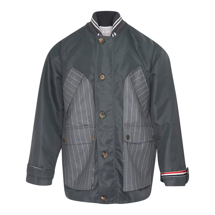 Back view of Thom Browne Cropped Field Jacket in slate grey with ribbed collar, signature red, white, and blue grosgrain trim at collar label, rear pocket tabs, and cuffs