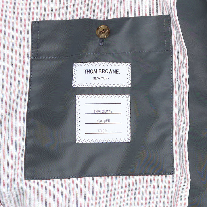 Back view of Thom Browne Cropped Field Jacket in slate grey with ribbed collar, signature red, white, and blue grosgrain trim at collar label, rear pocket tabs, and cuffs
