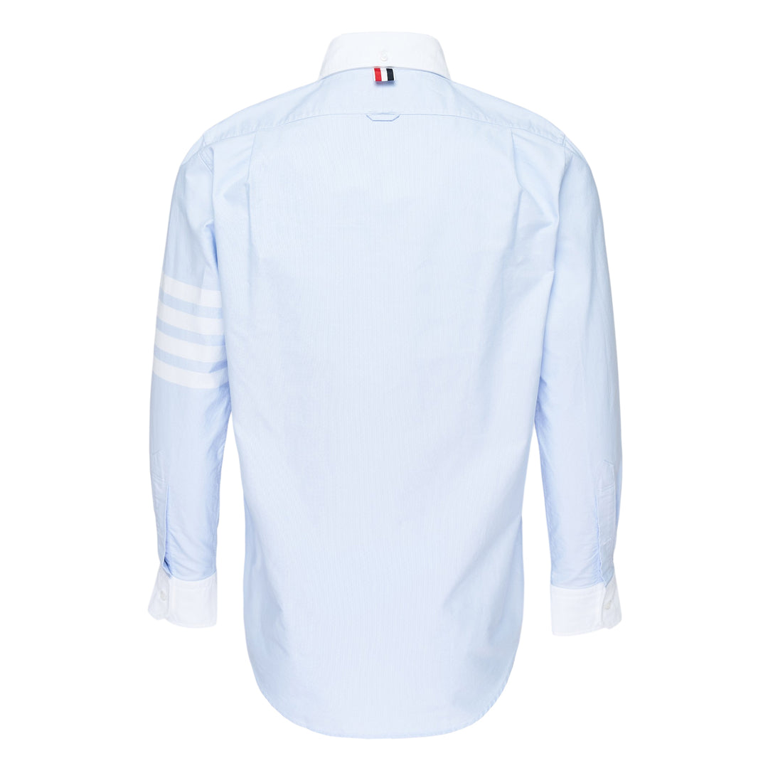 Thom Browne straight fit light blue Oxford long sleeve shirt with contrast white button-down collar, double cuffs, four-bar stripe on sleeve, and chest patch pocket