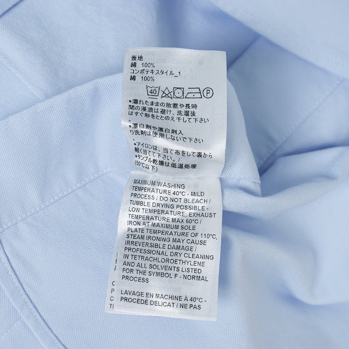 Thom Browne straight fit light blue Oxford long sleeve shirt with contrast white button-down collar, double cuffs, four-bar stripe on sleeve, and chest patch pocket