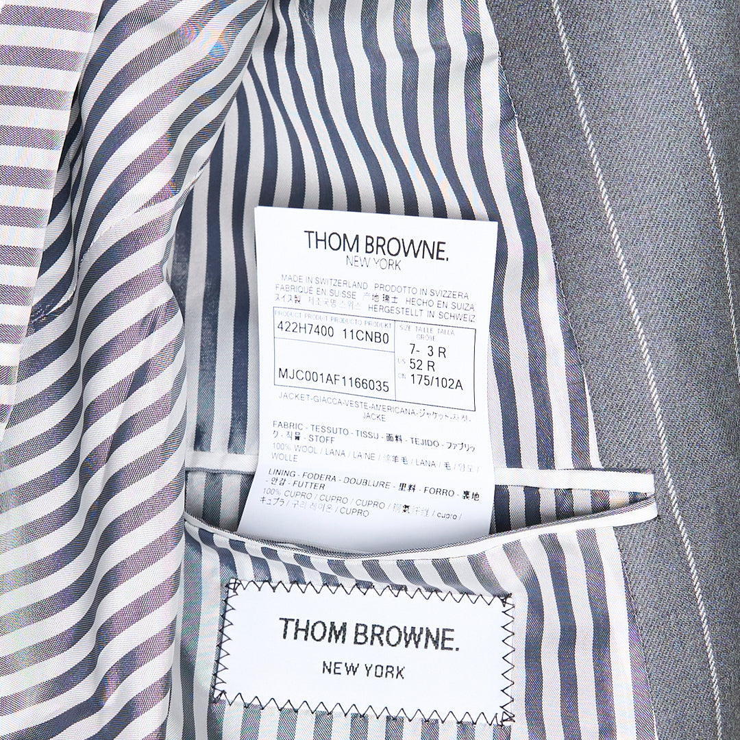Thom Browne grey chalk pinstripe single-breasted blazer with notch lapels, three-button closure, and flap hip pockets