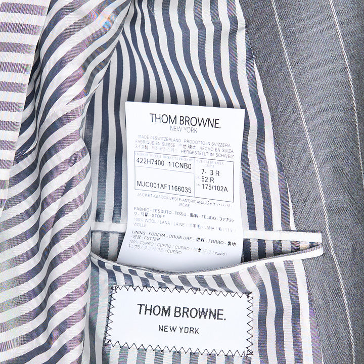Thom Browne grey chalk pinstripe single-breasted blazer with notch lapels, three-button closure, and flap hip pockets