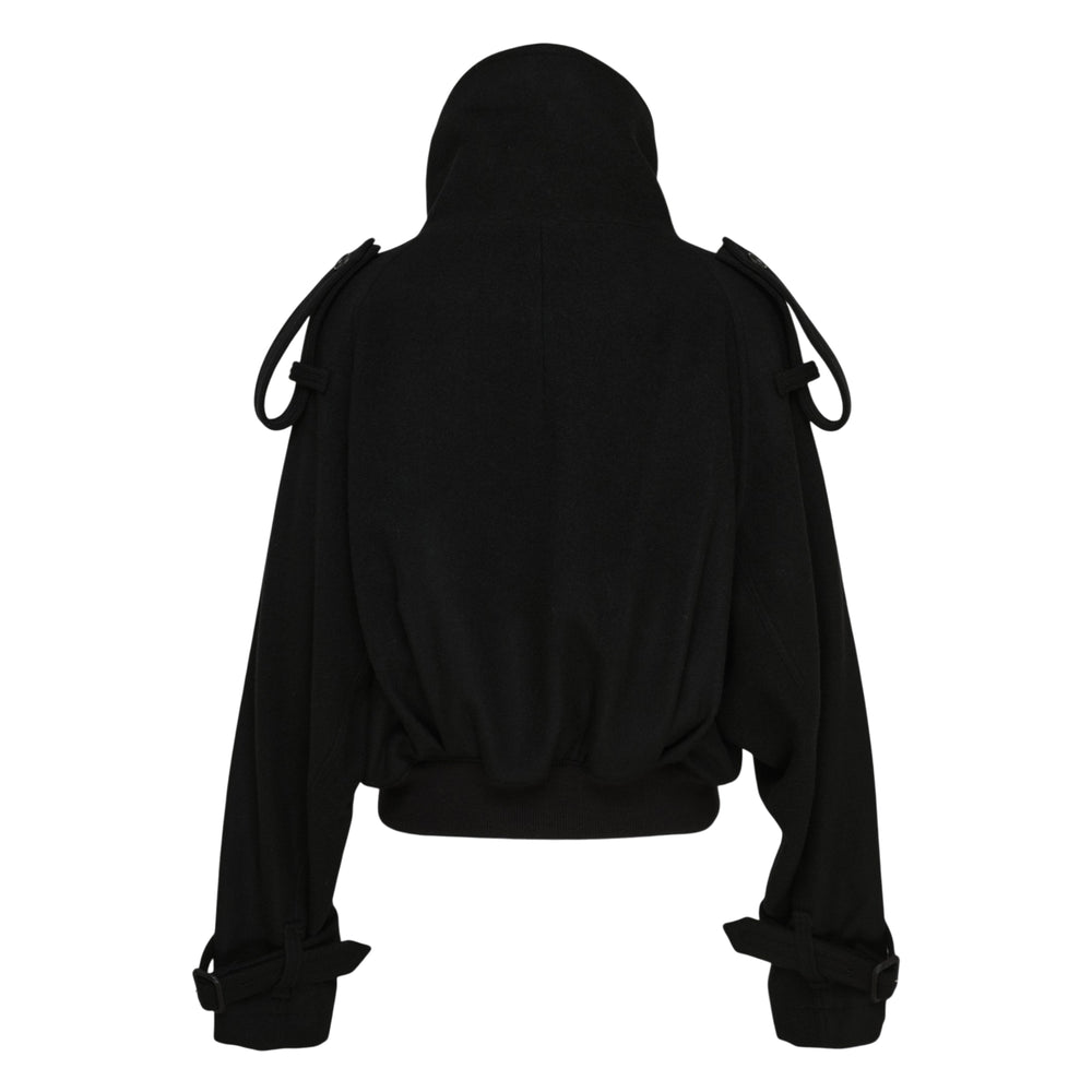 Yohji Yamamoto Short Trench Jacket in black — front view showing double-breasted button closure, sculptural funnel collar, epaulette shoulder detailing, and belted cuffs