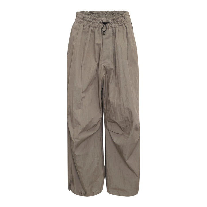 Yohji Yamamoto wide leg parachute pants in taupe with elasticated ruched waistband, drawstring toggle closure, and voluminous crinkled shell fabric