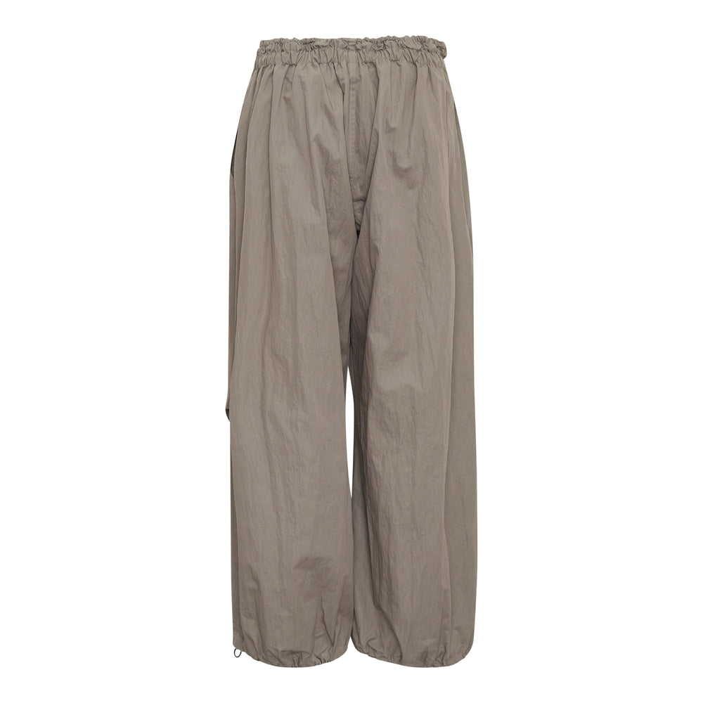 Yohji Yamamoto wide leg parachute pants in taupe with elasticated ruched waistband, drawstring toggle closure, and voluminous crinkled shell fabric