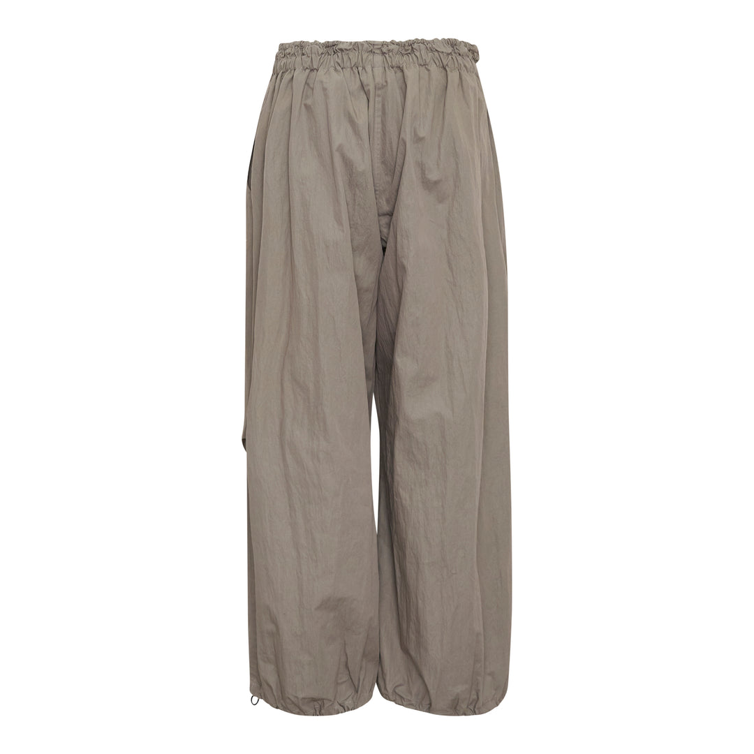 Yohji Yamamoto wide leg parachute pants in taupe with elasticated ruched waistband, drawstring toggle closure, and voluminous crinkled shell fabric