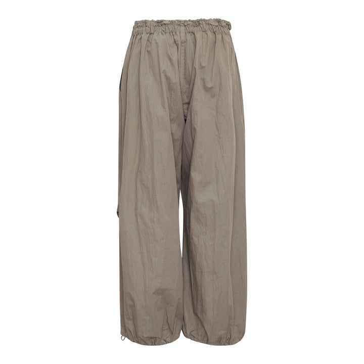 Yohji Yamamoto wide leg parachute pants in taupe with elasticated ruched waistband, drawstring toggle closure, and voluminous crinkled shell fabric