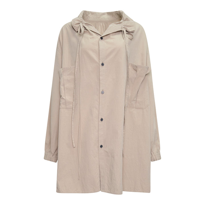 Y's Gather Collar Hooded Coat in sand beige, featuring a drawstring gathered hood with bow-tie fastenings, button-front closure, large hip patch pockets, and elasticated cuffs, displayed flat on a white background
