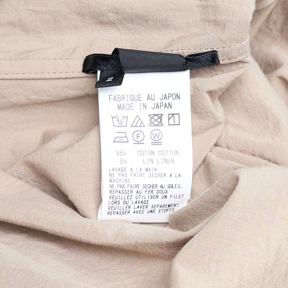 Y's Gather Collar Hooded Coat in sand beige, featuring a drawstring gathered hood with bow-tie fastenings, button-front closure, large hip patch pockets, and elasticated cuffs, displayed flat on a white background