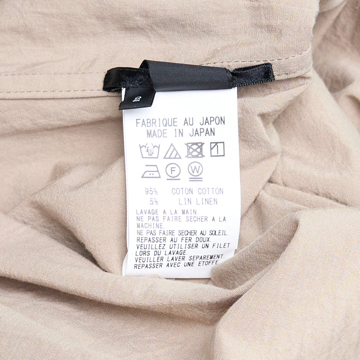 Y's Gather Collar Hooded Coat in sand beige, featuring a drawstring gathered hood with bow-tie fastenings, button-front closure, large hip patch pockets, and elasticated cuffs, displayed flat on a white background
