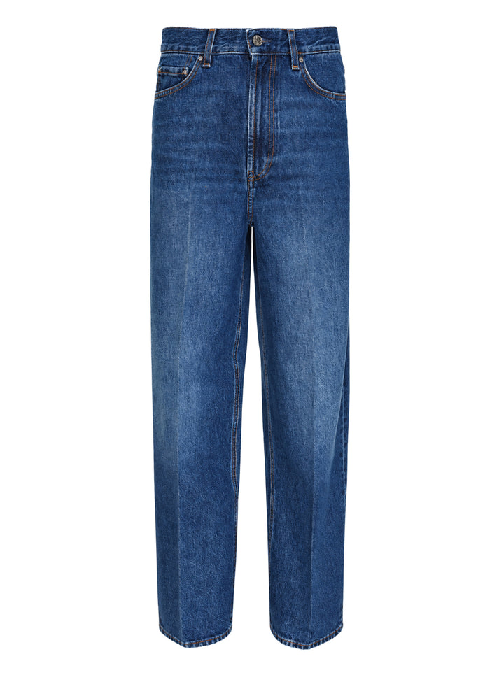 Toteme Wide Leg Jeans in mid-wash blue denim with a high-rise waist, contrast orange stitching, and a relaxed wide leg silhouette