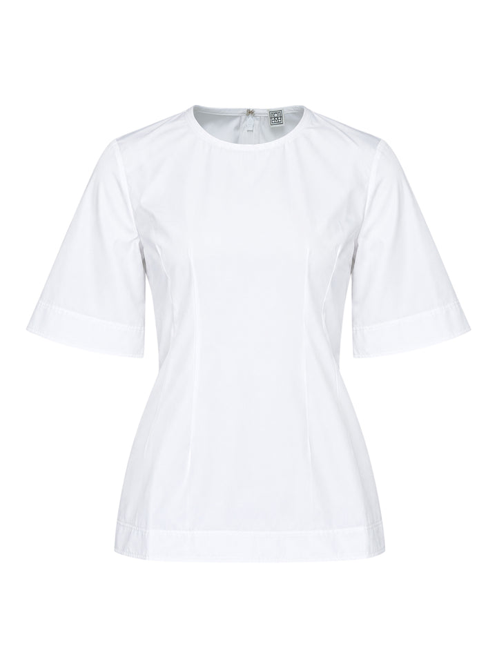 Toteme Sculptural Cotton Top in white, featuring a fitted seamed bodice, round neckline, and short fluted sleeves with a folded hem detail, shown from the front against a white background