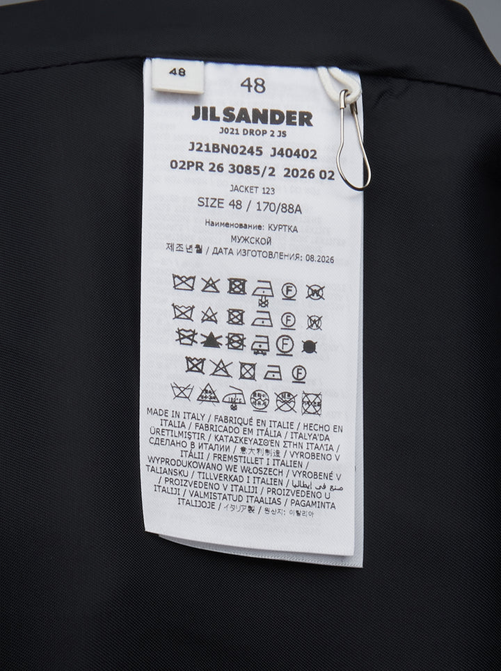 Jil Sander navy fil-a-fil wool jacket with camp collar, four-button fastening, and curved flap pockets with metal hardware — front view on white background - view 3