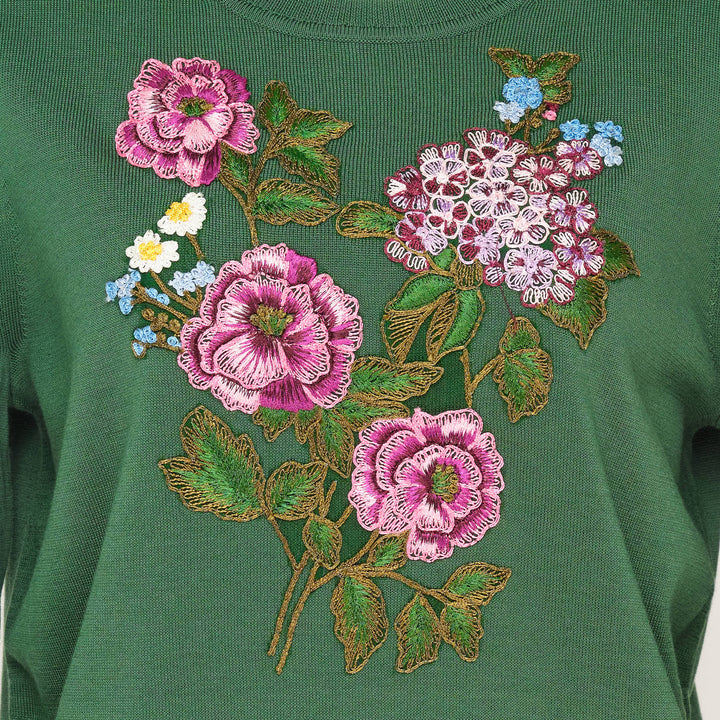 Carolina Herrera forest green long sleeve crew neck sweater with a large multi-floral embroidered bouquet featuring pink roses, hydrangeas, and wildflowers on the chest