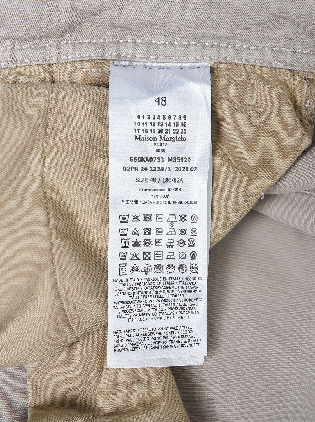 Maison Margiela stone cotton pants with a twisted seam and contrast tan tape trim, shown from the front - view 4