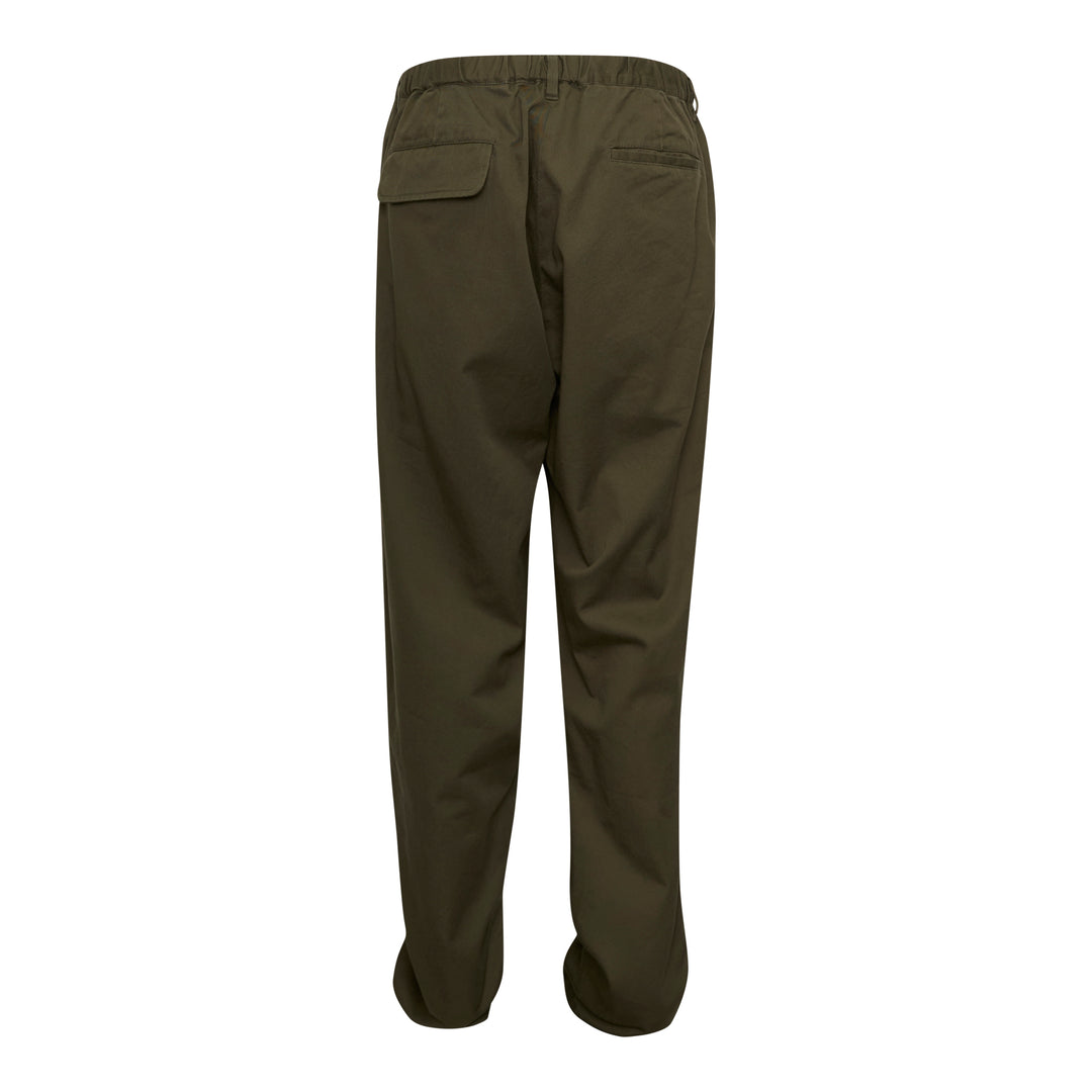 Undercover Witch Hand Elastic Waist Pants in olive green, featuring a tonal black witch claw and serpentine logo graphic on the leg and a concentric spiral drip graphic at the hip, with an elasticated waistband and relaxed wide-leg cut
