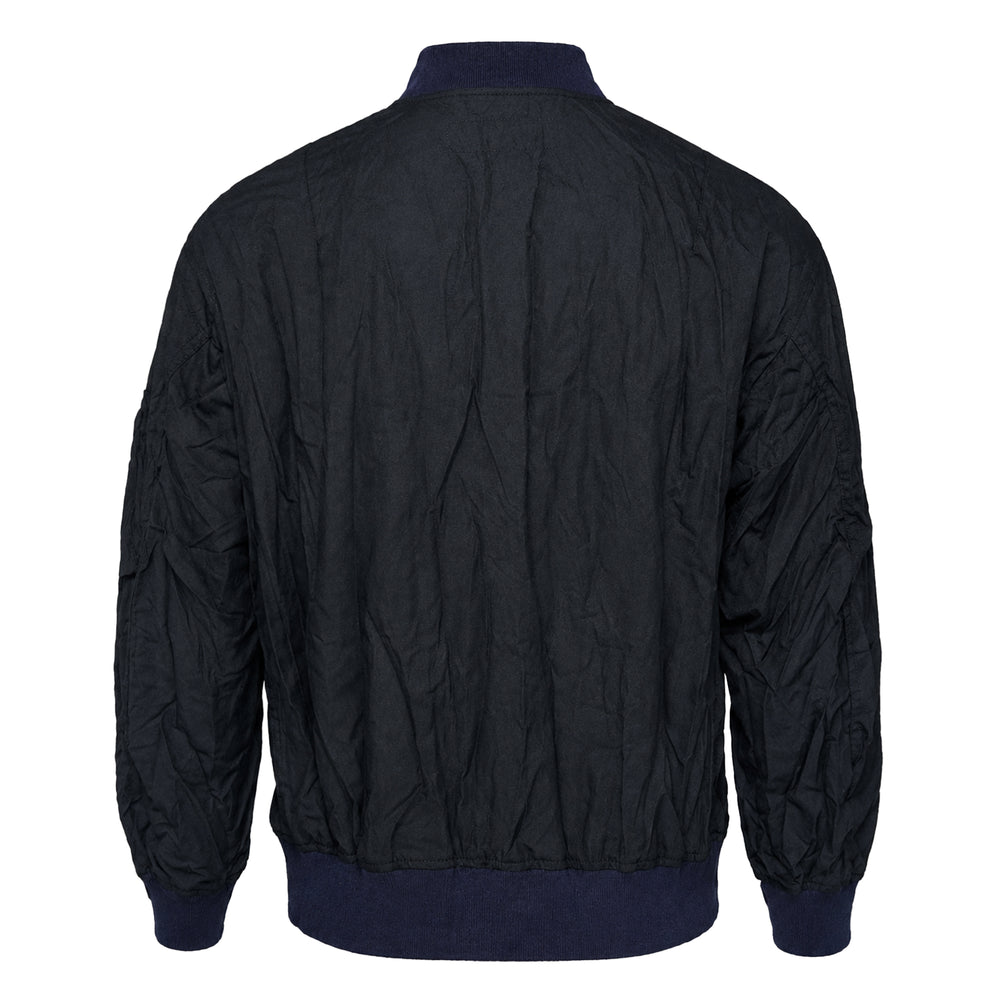 Comme des Garçons Homme polyester wool twill blouson in crinkled navy, featuring silver zip hardware, ribbed navy trim, front flap pockets, and a zipped sleeve utility pocket