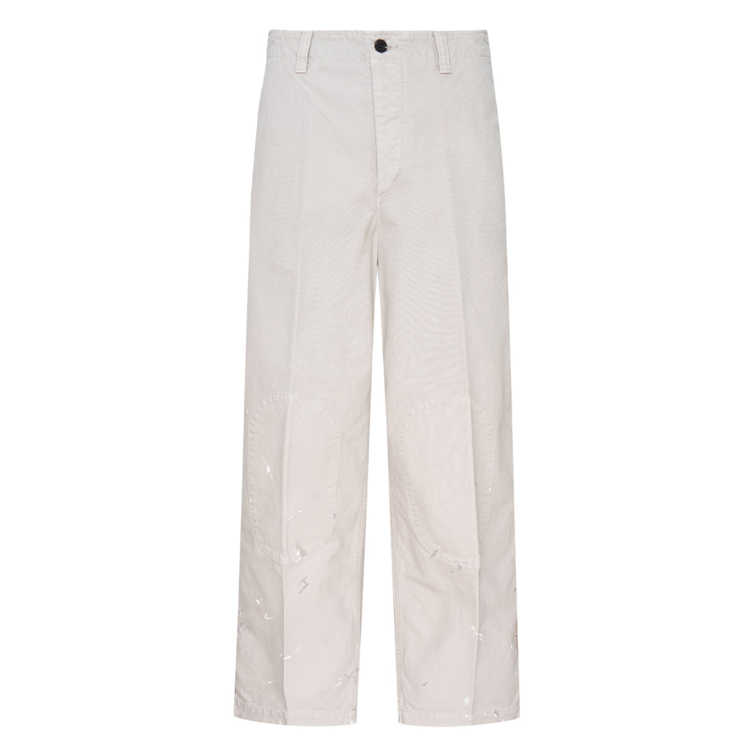 visvim Survey Damaged Pants in light stone, wide-leg silhouette with paint-splatter distressing on lower leg panels, front view on white background