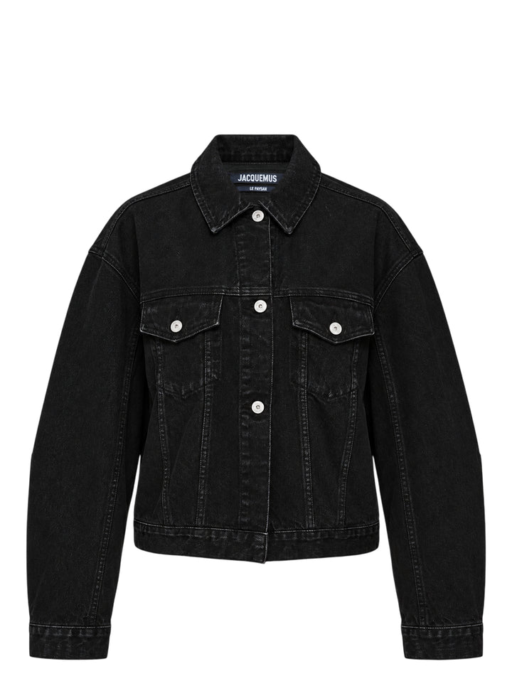 Jacquemus oversized black denim jacket with rounded sleeves, flap chest pockets and pearlised buttons, shown from the front