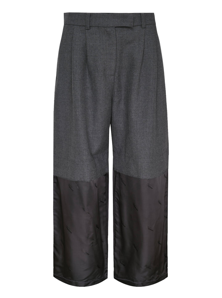 Vaquera women's wide-leg trousers in charcoal grey with pleated front and a raw-edged dark satin lower leg panel with tonal logo print