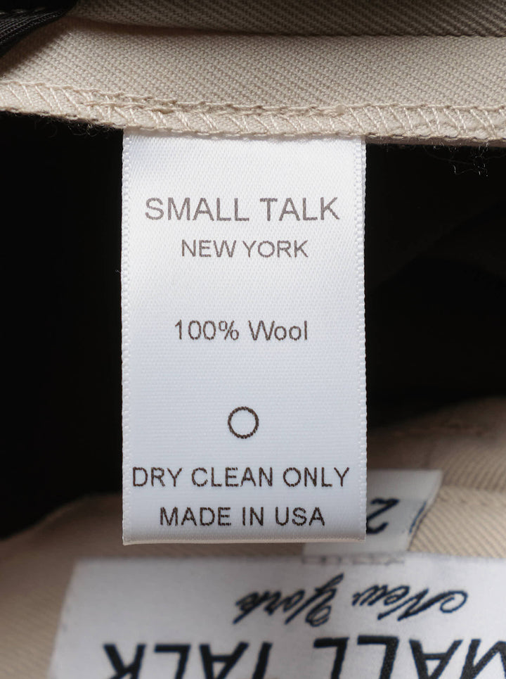 Small Talk Studio double pleat wide-leg trousers in a stone neutral tone, shown front-facing with tab waistband closure - view 3