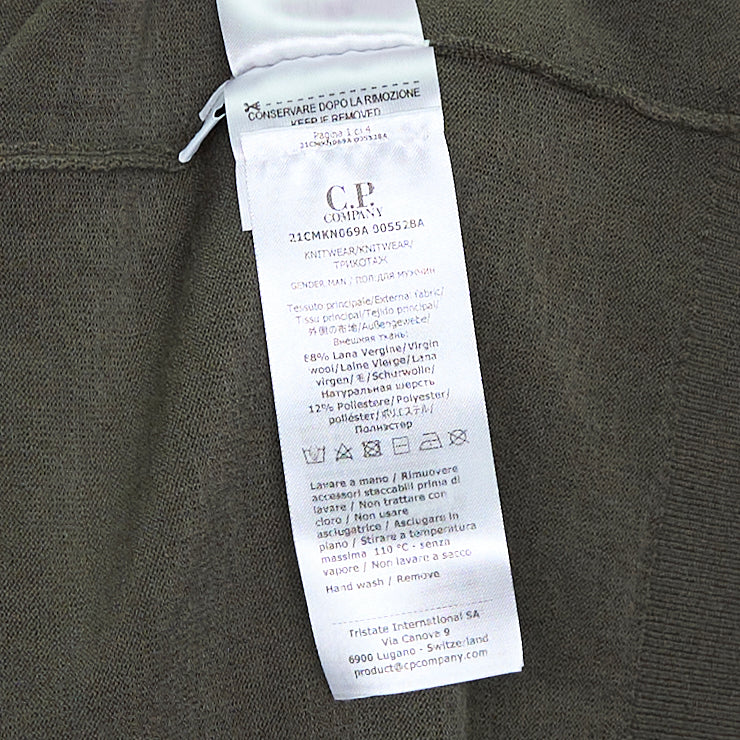 C.P. Company Extrafine Merino Wool Lens Crewneck Sweater in olive green, back view showing sleeve utility pocket and circular lens badge