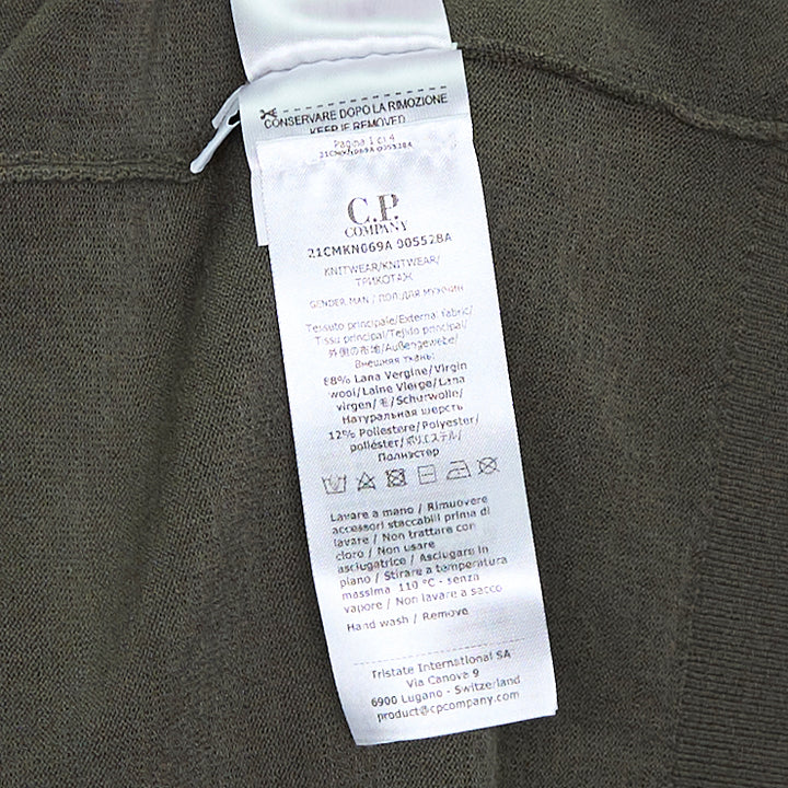 C.P. Company Extrafine Merino Wool Lens Crewneck Sweater in olive green, back view showing sleeve utility pocket and circular lens badge