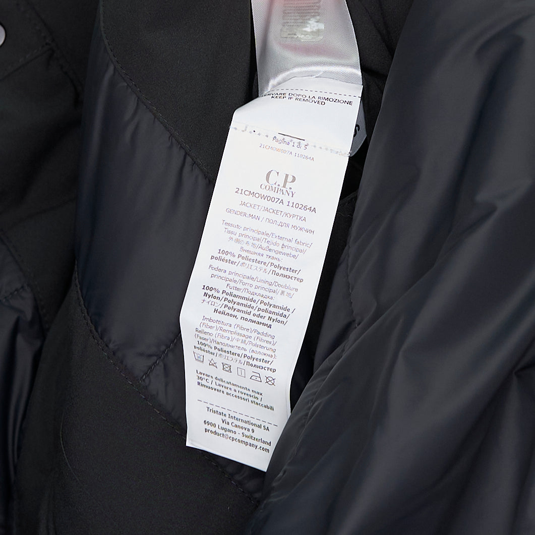 C.P. Company Pro-Tek Primaloft Silver Lens Jacket in dark grey, front view, featuring a padded high collar, snap-button storm placket, and signature goggle lens sleeve pocket