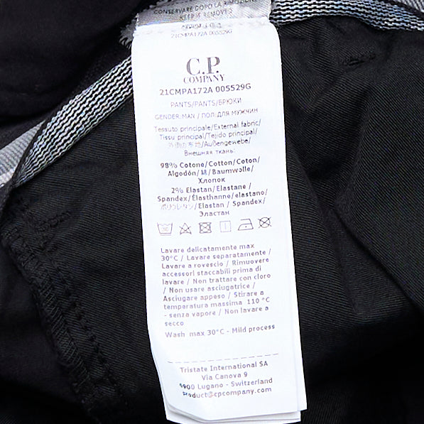 C.P. Company Stretch Sateen Ergonomic Cargo Pants in black, featuring a slim fit, flap thigh pockets, and tonal lens badge, shown from the front