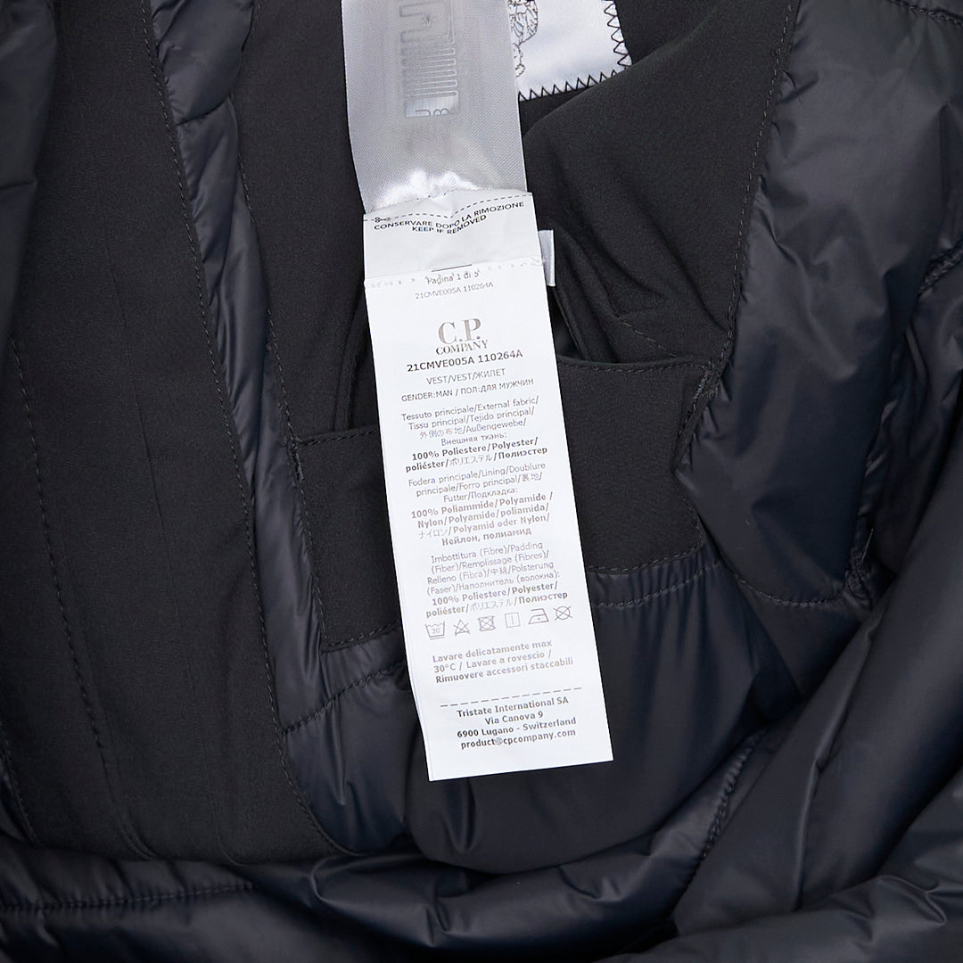 C.P. Company Pro-Tek Primaloft Silver Vest in dark grey, front view, showing stand collar, hidden zip placket, chest zip pockets, lower patch pockets, and NFC badge at the hem
