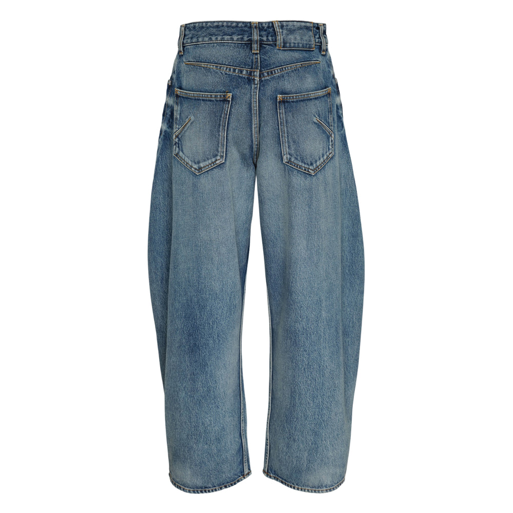 Alaïa Rodeo Jeans in vintage blue denim, featuring a high-rise waist and sculptural barrel-leg silhouette with curved seams and a cropped hem