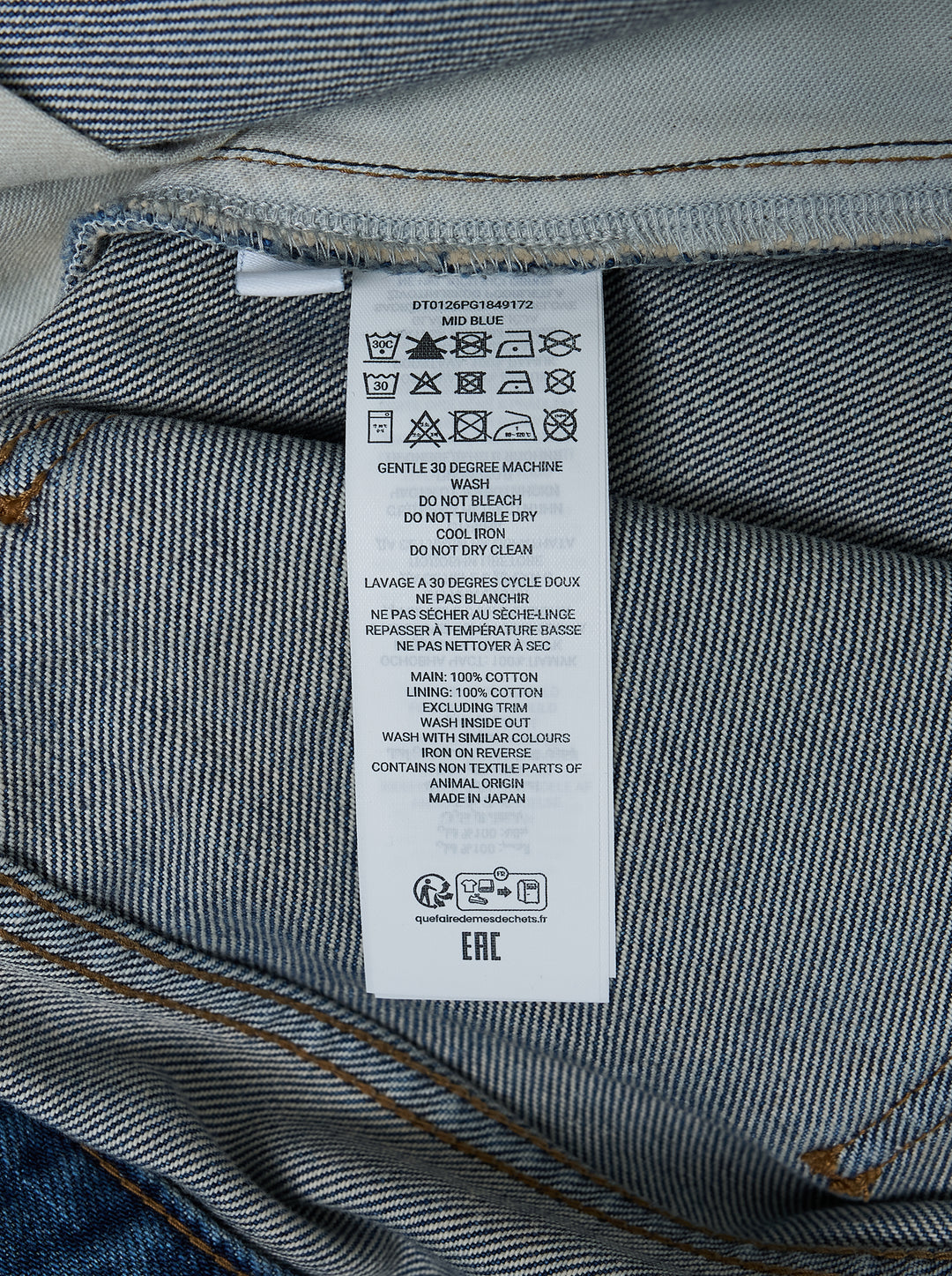 JW Anderson Twisted Workwear Jeans in washed blue denim with curved twisted seams, embroidered front pocket and leather logo patch at the waistband - view 5