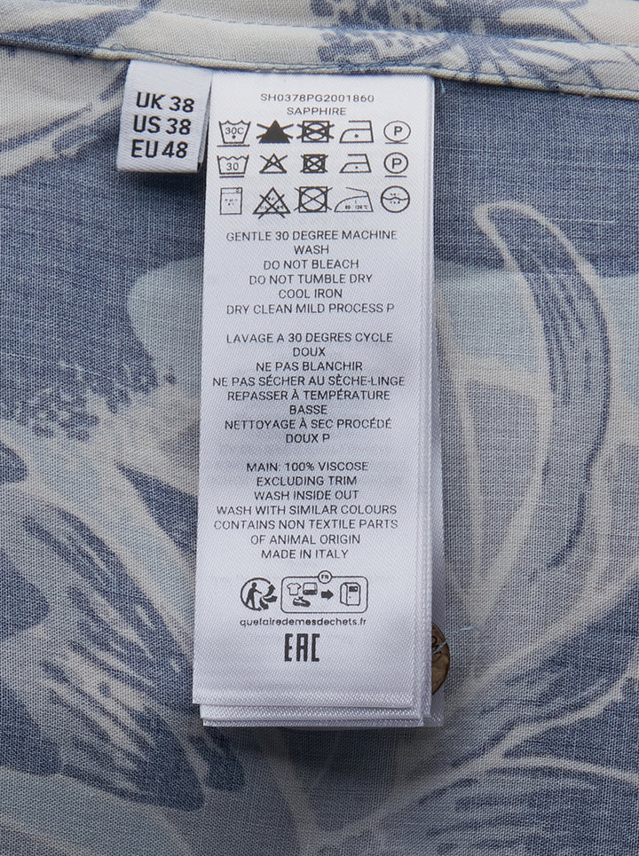 JW Anderson Hawaii Camp Collar Short Sleeve Shirt in a large-scale tropical floral print featuring navy, sky blue, and cream tones, with tortoiseshell buttons and a chest patch pocket - view 3