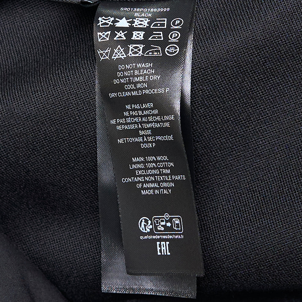 JW Anderson black Folded Wrap Shorts with asymmetric diagonal overlap front, cuffed hem with button detail, and patch pocket