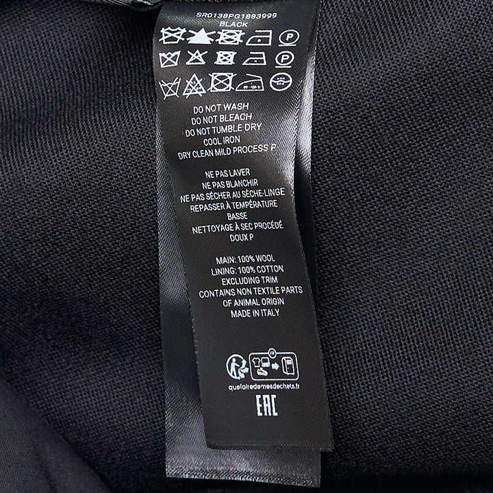JW Anderson black Folded Wrap Shorts with asymmetric diagonal overlap front, cuffed hem with button detail, and patch pocket