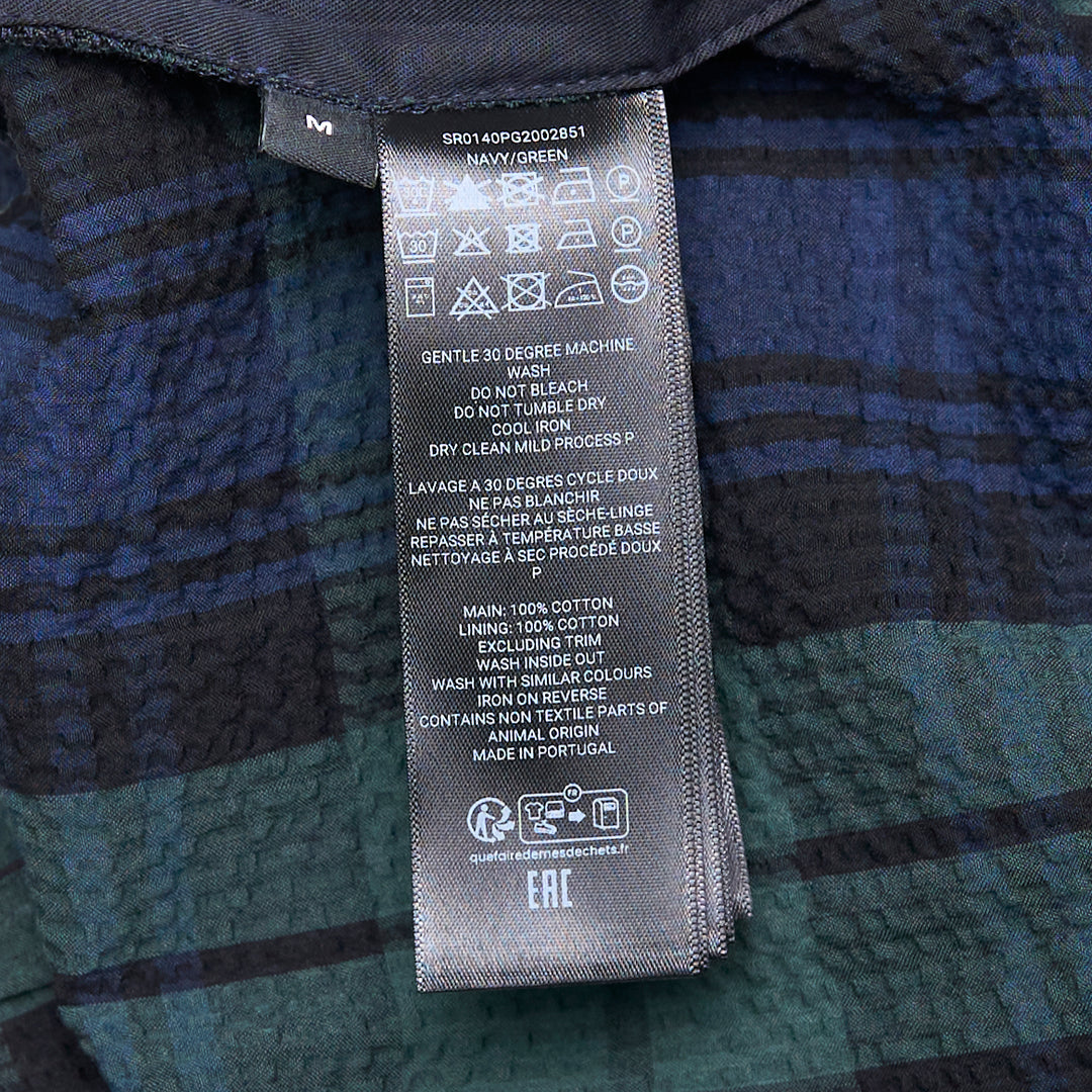 JW Anderson Drawstring Seersucker Shorts in Black Watch tartan, featuring green, navy, and black plaid on a crinkled cotton fabric with an elasticated drawstring waistband and side pockets