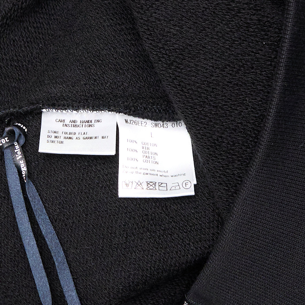 Mastermind Millefeuille Zip-Up Hoodie in black, featuring a two-way silver zip, drawstring hood, and exposed raw-edge layered detail along the shoulder and sleeve seams