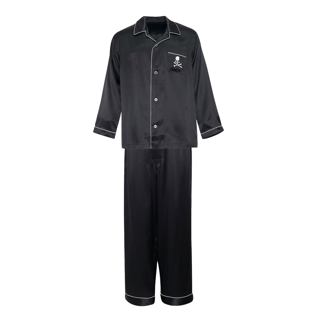 Mastermind black satin pajama set with skull and crossbones embroidery on the chest pocket, white contrast piping trim, button-front long-sleeve top, and relaxed wide-leg trousers