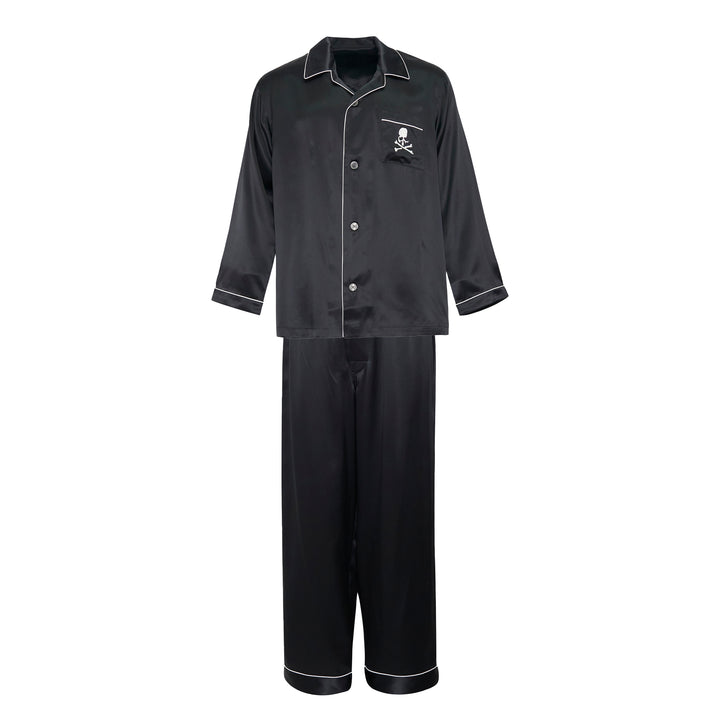Mastermind black satin pajama set with skull and crossbones embroidery on the chest pocket, white contrast piping trim, button-front long-sleeve top, and relaxed wide-leg trousers