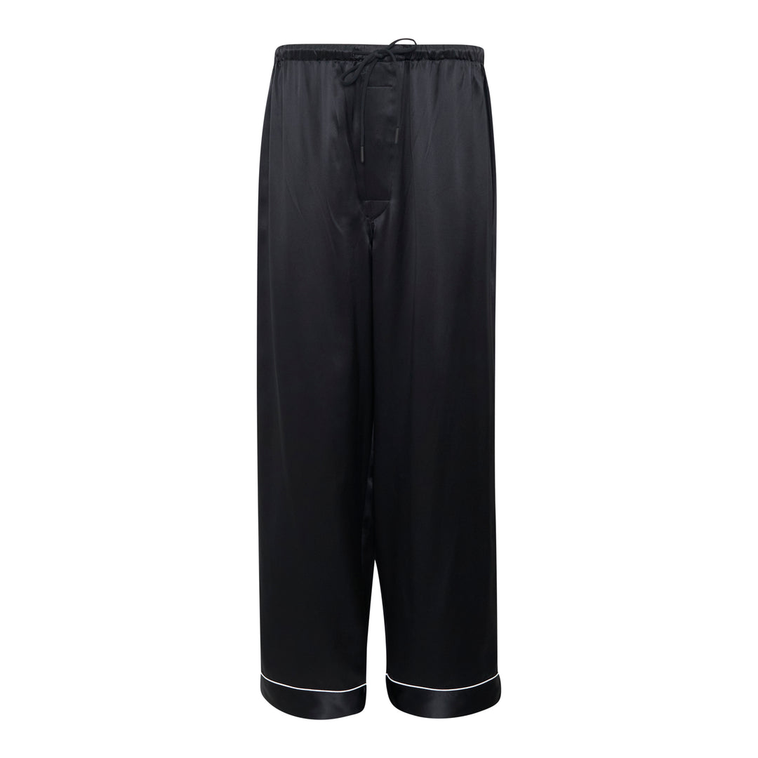 Mastermind black satin pajama set with skull and crossbones embroidery on the chest pocket, white contrast piping trim, button-front long-sleeve top, and relaxed wide-leg trousers