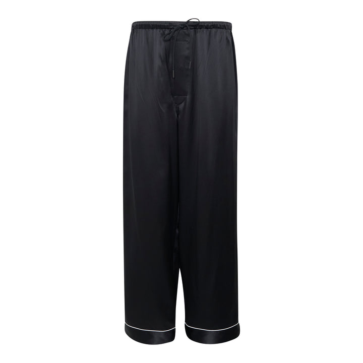 Mastermind black satin pajama set with skull and crossbones embroidery on the chest pocket, white contrast piping trim, button-front long-sleeve top, and relaxed wide-leg trousers