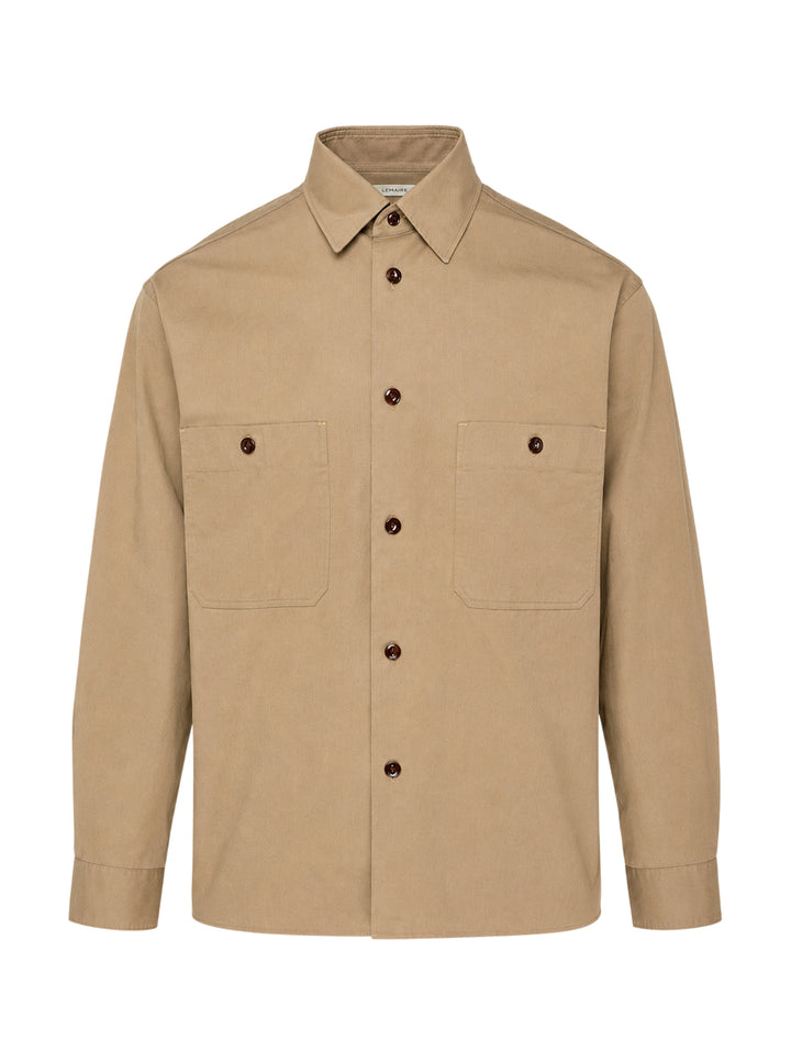Lemaire Two Pockets Long Sleeve Shirt in tan cotton with dual patch chest pockets, dark tortoiseshell buttons, and a relaxed boxy silhouette, shown on a white background