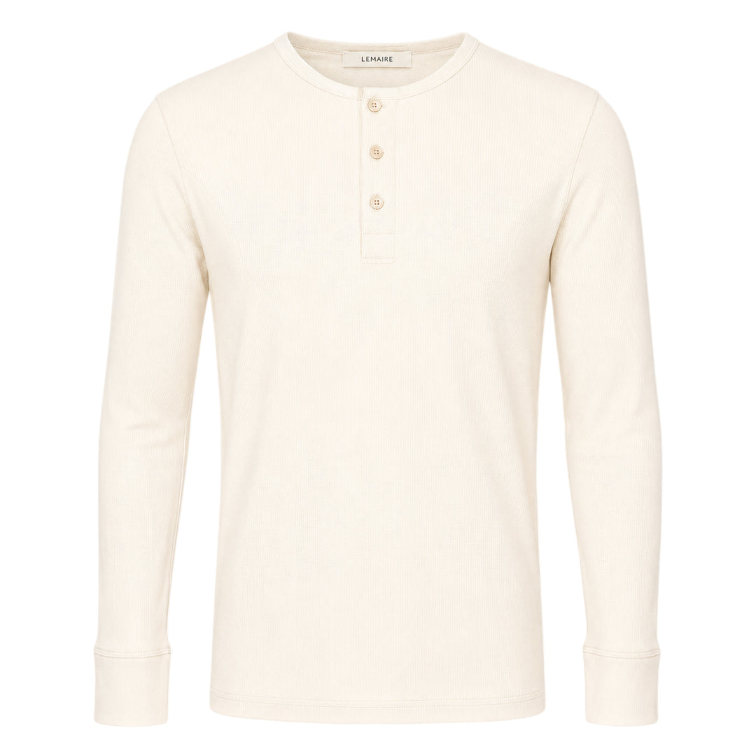 Lemaire long sleeve henley tee in off-white ribbed cotton with a three-button placket and ribbed cuffs, displayed flat on a white background